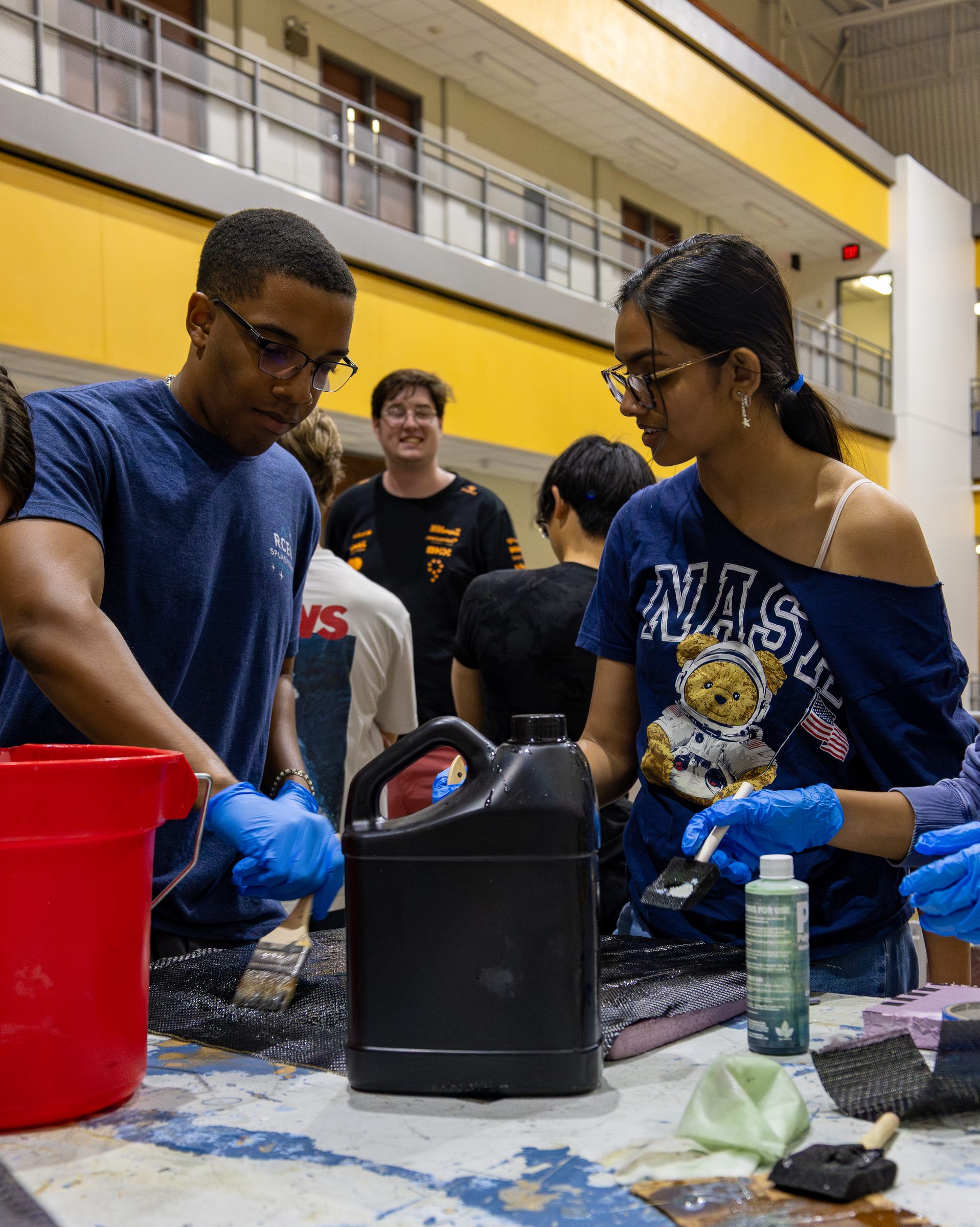 Team members mixing epoxy during body panel prep