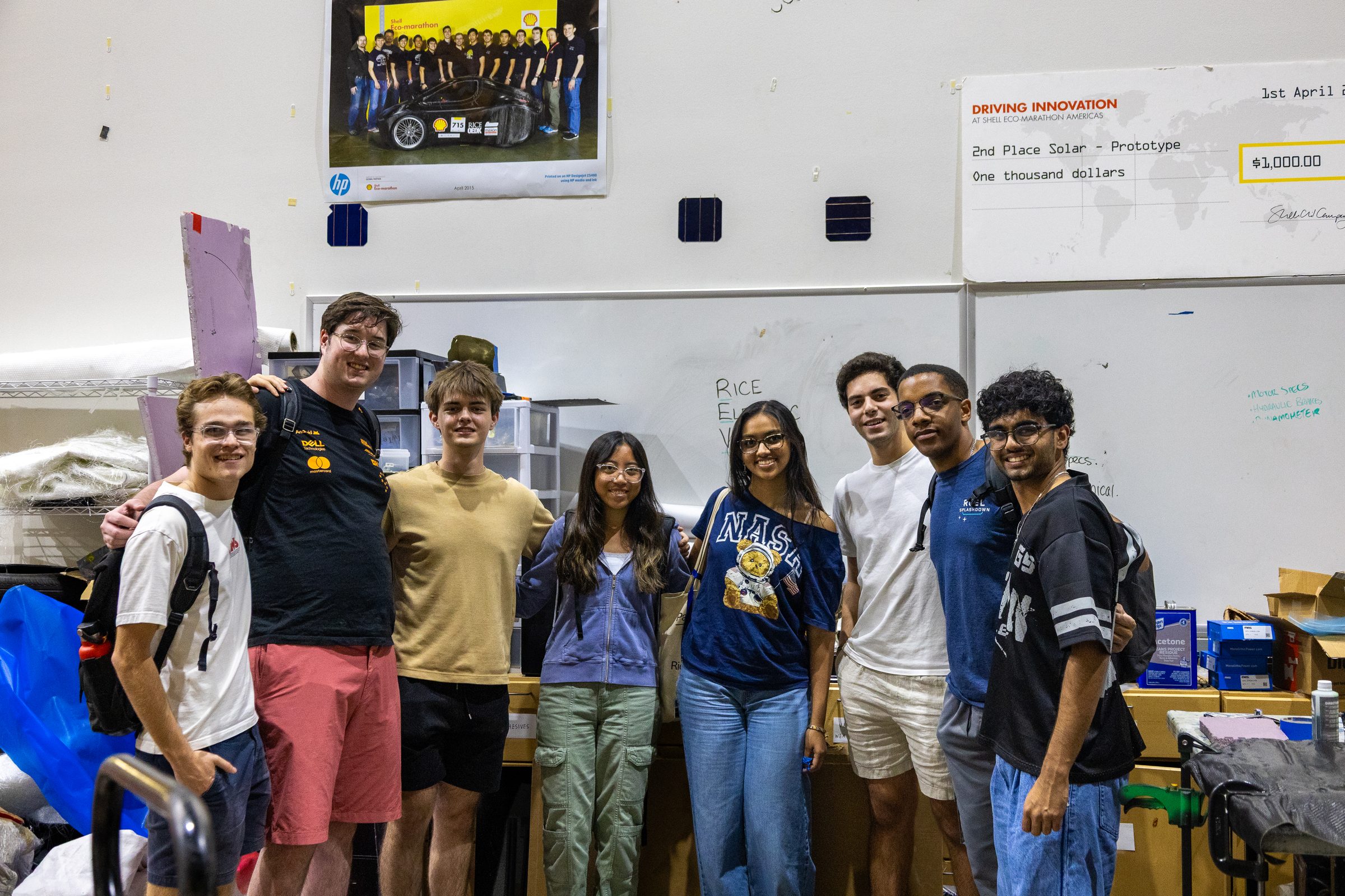 The team posing with a results board showing a 1st place solar prototype finish